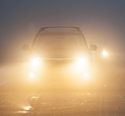 Bright-headlights-of-a-car-driving-on-foggy-winter-road.jpg