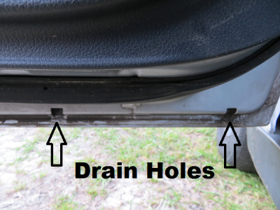 Drain holes under driver door on car.png